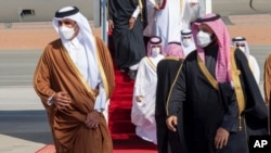 In this photo provided by the Saudi Royal Court, Saudi Arabia's Crown Prince Mohammed bin Salman, right, welcomes Qatar's Emir Sheikh Tamim bin Hamad al-Thani upon his arrival to attend the Gulf Cooperation Council's 41st Summit in Al-Ula, Jan. 5, 2021.