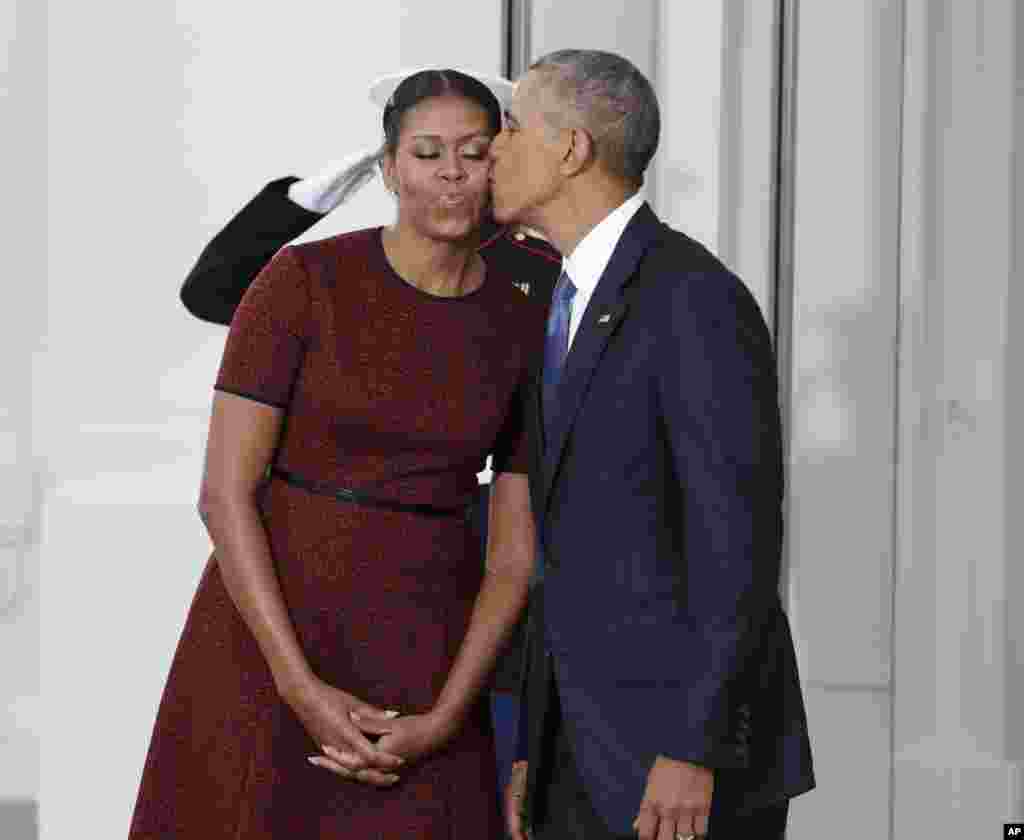 Barack Obama embrasse la Première dame Michelle Obama alors qu&#39;ils attendent pour le président élu Donald Trumpet sa femme Melania, le 20 janvier 2017, à la Maison Blanche à Washington.