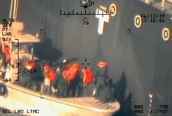 This image released by the Pentagon June 17, 2019, and taken from a U.S. Navy helicopter, shows what the Navy says are members of the Islamic Revolutionary Guard Corps Navy removing an unexploded limpet mine from the M/T Kokuka Courageous.