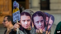 Čovek prodaje maske sa likom Grete Tunberg tokom protesta zbog klimatskih promena u Sandiegu, Čile, 27. septembra 2019.