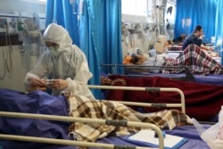 A medic treats a patient infected with the new coronavirus, at a hospital in Tehran, Iran, March 8, 2020.