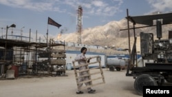 FILE - An Iranian laborer works at a unit of South Pars Gas field in Asalouyeh Seaport, north of Persian Gulf, Iran.