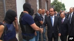 Le président français François Hollande donne une poignée de main à des policiers après la prise d'otages dans une église dans un village près de Rouen, France, le 26 juillet 2016.