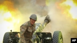An Armenian serviceman fires a cannon toward Azerbaijan positions in the self-proclaimed Republic of Nagorno-Karabakh, Azerbaijan, Sept. 29, 2020.