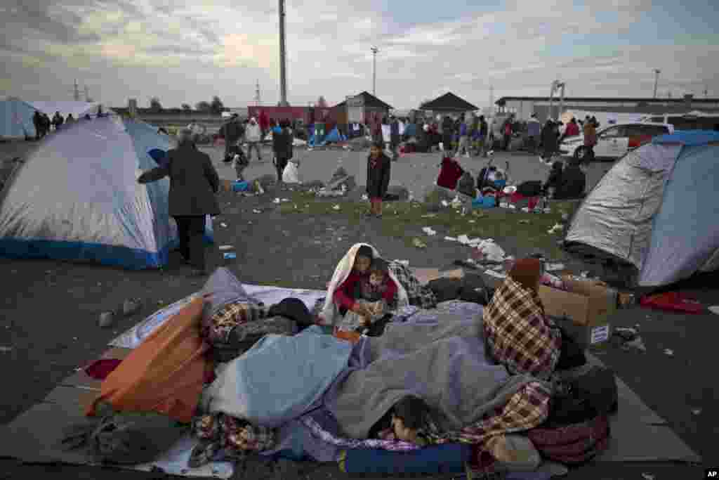 Afghan refugees are wrapped themselves with blankets to shelter from the morning cold after spending the night at a collection point in the truck parking lot of the former border station on the Austrian side of the Hungarian-Austrian border near Nickelsdo. European Union ministers agreed to relocate 120,000 migrants in a move intended to ease the strain on Greece and Italy which are on the frontline of the continent&rsquo;s overwhelming migrant crisis.