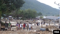 Penduduk menyaksikan kerusakan yang ditimbulkan oleh banjir bandang di Wasior, Papua Barat.