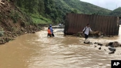 Residents wade through flood water in northern province of Son La, Vietnam Thursday Oct. 12, 2017.
