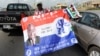 A vendor hawks flags of the ruling National Democratic Congress (NDC) and New Patriotic Party (NPP) in a traffic jam in Kasoa, Central Region on December 1, 2012 ahead of the December 7 presidential elections in Ghana . 