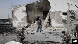 Afghan investigation team members assess the damage caused at the scene of a militant attack in Kabul, Afghanistan, May 2, 2012.