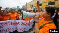 រូបឯកសារ៖ ក្រុម​កម្មករ​រោង​ចក្រ​កាត់​ដេរ​សម្លៀក​បំពាក់​​​ស្រែក​ពាក្យ​ស្លោក​ក​និង​កាន់​​​បដា​នៅ​ក្នុង​​ការ​​​ចាប់​ផ្តើម​ដំបូង​​នៃ​​​យុទ្ធនាការ​ដំឡើង​​ប្រាក់​ឈ្នួល​ដល់​ក្រុម​កម្មករ​ឲ្យ​​បាន​ដល់​១៧៧​ដុល្លារ​ក្នុង​មួយ​ខែ កាល​ពី​ថ្ងៃ​​ពុធ ទី​១៧ ខែ​កញ្ញា ឆ្នាំ​២០១៤។​ (Reuters)