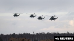 Belarusian military helicopters fly during the joint exercises of the armed forces of Russia and Belarus at a firing range in the Brest Region, Belarus, Feb. 3, 2022.