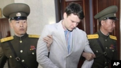 Mahasiswa AS Otto Warmbier (tengah) dikawal di Mahkamah Agung di Pyongyang, Korea Utara (16/3). (AP/Jon Choi Jin)