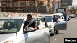 People push their cars due to a lack of fuel, near a gas station in Dora, Lebanon, Aug. 17, 2021. 