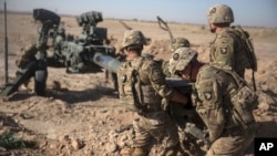 FILE - U.S. soldiers with Task Force Iron maneuver an M-777 howitzer so it can be towed into position at Bost Airfield, Afghanistan, June 10, 2017. (Operation Resolute Support)