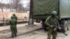 Soldiers without insignia guard buildings in the Crimean capital, a day after the Ukrainian prime minister called for Russian help, Simferopol, Ukraine, March 2, 2014. (Elizabeth Arrott/VOA).