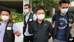 Ryan Law, second from right, Apple Daily's chief editor, is arrested by police officers in Hong Kong Thursday, June 17, 2021. (AP)