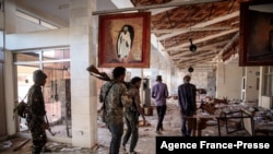 Amhara Fano militia fighters walk in the ransacked terminal at the Lalibela airport in Lalibela, Ethiopia, Dec. 7, 2021.
