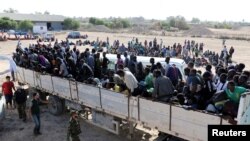 Migrants rides in a truck before they are transported to a detention center, in the coastal city of Sabratha, Libya, Oct. 7, 2017. 