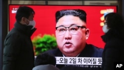 People walk by a TV screen showing North Korean leader Kim Jong Un during a ruling party congress, at the Seoul Railway Station in Seoul, South Korea, Jan. 6, 2021. 