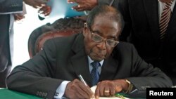 FILE - President Robert Mugabe signs Zimbabwe's new constitution into law in Harare, May 22, 2013.