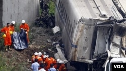 Regu penyelamat menggotong tubuh korban tewas yang ditemukan di antara rongsokan kereta api yang bertabrakan di Propinsi Zhejiang (24/7).