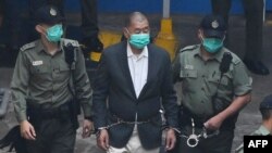 (FILES) Hong Kong pro-democracy media tycoon Jimmy Lai (C) is led into a police van as he heads to court to be charged under the territory's controversial new national security law on December 12, 2020.