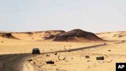 Une voiture conduit sur une route reliant Sebha et Ubari au sud de la Libye, le 24 décembre 2013. 