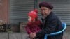 A man sits with an infant in Balkh, northwest of Mazar-i-Sharif 