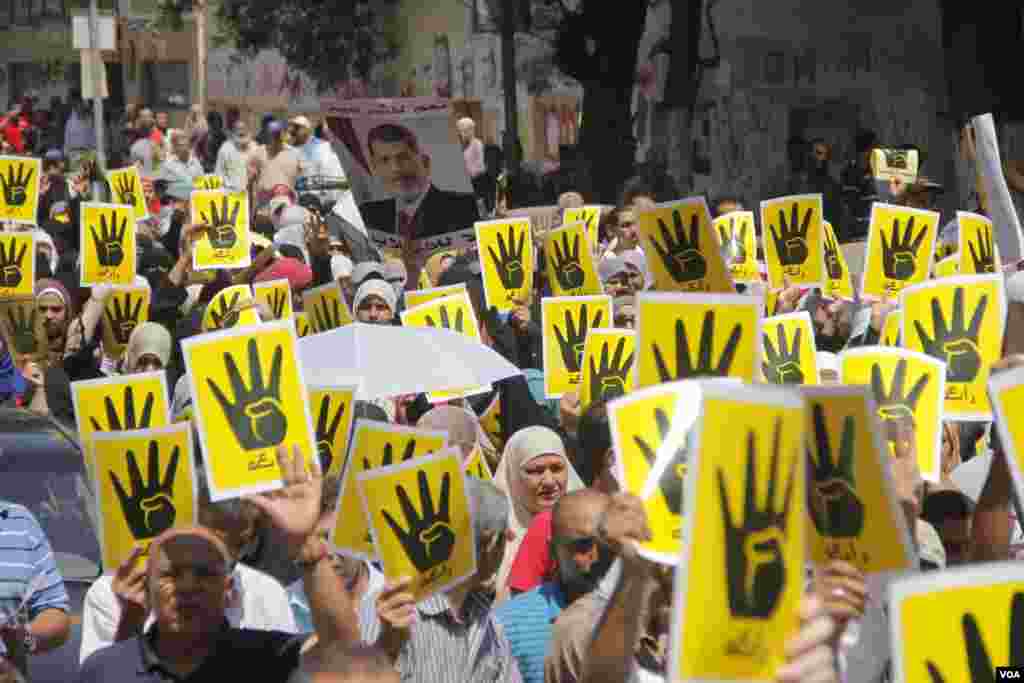 Para pengunjuk rasa mengangkat empat tangannya sebagai simbol solidaritas mereka atas &#39;Rabaa&#39; - protes duduk damai - di Kairo, 23 Agustus 2013. Rabaa dalam bahasa Arab berarti empat. (H. Elrasam untuk VOA)