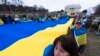 Люди несуть величезний український прапор під час мітингу в центрі Вашингтона біля меморіалу Лінкольна, 24 лютого 2024 р. (Фото: AP Photo/Manuel Balce Ceneta)