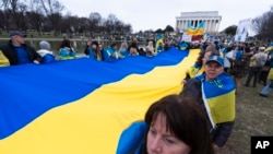 Люди несуть величезний український прапор під час мітингу в центрі Вашингтона біля меморіалу Лінкольна, 24 лютого 2024 р. (Фото: AP Photo/Manuel Balce Ceneta)