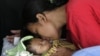 Seorang ibu Indonesia mencium bayinya yang berusia satu bulan setelah dirawat di sebuah rumah sakit di Yogyakarta 28 Mei 2006. Dampak pandemi Covid-19 ikut berdampak pada penurunan capaian temuan pneumonia pada balita di Indonesia. (Foto: Reuters/Beawiharta)