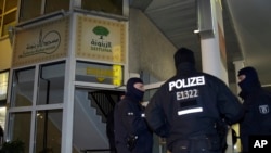 Police officers guard the 'Seituna' cultural society in Berlin, Germany, Thursday, Nov. 26, 2015.