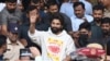 হায়দ্রাবাদে পুলিশ তাঁকে গ্রেপ্তার করার আগে স্বাস্থ্য পরীক্ষার পর হাসপাতাল থেকে বেরোনোর সময়ে ভক্তদের হাত নেড়ে শুভেচ্ছা জানাচ্ছেন ভারতীয় অভিনেতা আল্লু আর্জুন ।১৩ ডিসেম্বর, ২০২৪। 