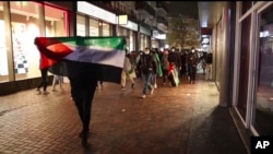 FILE - In this image taken from video, pro-Palestinian supporters march with Palestinian flags near the Ajax stadium in Amsterdam, the Netherlands, Nov. 7, 2024.