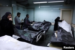 Ljudi gledaju tijela za koja se vjeruje da su zatvorenici iz zatvora Sednaya, prema forenzičkom službeniku Zaheru al-Taqešu, u bolnici Al Mojtahed, nakon što su pobunjenici zauzeli glavni grad i zbacili sirijskog Bashara al-Assada, u Damasku, Sirija, 10. decembra , 2024.