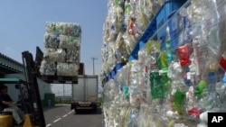 Tumpupkan botol Polietilena tereftalat (atau PET) dibawa ke gudang sebelum dihancurkan untuk didaur ulang di Tokyo PET Bottle Recycle Co. in Tokyo, 13 Agustus 2002.