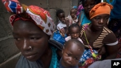 Des femmes déplacées avec leurs enfants attendent de l'aide dans un bâtiment utilisé par des réfugiés comme refuge à Pemba, au Mozambique, après avoir fui les attaques à Palma, dans le nord du Mozambique, le 19 avril 2021.