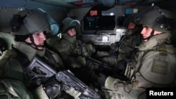 FILE - Russian service members sit inside a military vehicle as they take part in tactical exercises of an assault engineering unit at a training ground in Kamensk-Shakhtinsky in the Rostov region, Russia, Jan. 17, 2022. 