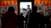 Visitors walk in front of a picture of China's President Xi Jinping at the Museum of the Communist Party of China in Beijing on November 11, 2021.