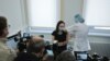 Journalists film as a woman gets injected with Sputnik-V vaccine against the coronavirus disease at a clinic in Moscow, Russia, Dec. 5, 2020.