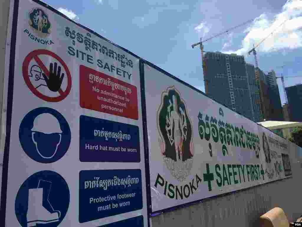 ស្លាក​សញ្ញា​«សុវត្ថិភាព»​ ក្នុង​បរិវេណ​វាយកម្ទេច​អគារប៊ូឌីញ​ រាជធានី​ភ្នំពេញ​ នាថ្ងៃទី​២៤​ ខែ​សីហា ឆ្នាំ​២០១៧។​ ទាំង​កម្មករ​ និង​អ្នកថតរូប​តម្រូវ​ឱ្យ​ពាក់មួក​ការពារ​ និង​អាវសុវត្ថភាព​ជា​ចាំបាច់​ ដើម្បី​ចូលក្បែរ​អគារប៊ូឌីញ​ អំឡុង​ពេល​វាយកម្ទេច។  (ហ៊ាន សុជា