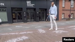 Seorang pria mengambil foto “cuitan-cuitan kebencian,” sebagai bagian dari proyek seni “#HEYTWITTER” yang dibuat oleh Shahak Shapira, di pelataran kantor Twitter di Hamburg, Jerman (YouTube via REUTERS) Germany Aug. 4, 2017 in this picture obtained from social media.