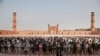 FILE - Small numbers of people offer Friday prayers at the grand Badshahi mosque, due to coronavirus outbreak, in Lahore, Pakistan, March 20, 2020.