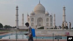 A man disinfects the premises of the Taj Mahal monument that was reopened after being closed for more than six months due to the coronavirus pandemic in Agra, India, Sept.21, 2020. 