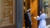 A woman is checked for her Covid-19 vaccination certificate in order to be allowed to enter a shop in Athens, Greece, Nov. 6, 2021. 
