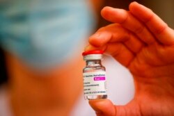 FILE - A member of the medical staff holds a vial of the AstraZeneca-Oxford COVID-19 vaccine at the South Ile-de-France Hospital Group in Melun, in the outskirts of Paris, Feb. 8, 2021.