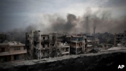 FILE - Smoke is seen rising over Saif Al Dawla district, in Aleppo, Syria.