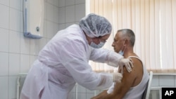 FILE - A Russian medical worker administers a shot of Russia's experimental Sputnik V coronavirus vaccine in Moscow, Russia, Sept. 15, 2020.