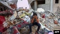 Mmoja wa vijana wa Palestina akitafakari juu ya vifusi vya nyumba zilizobomolewa kwenye kambi ya wakimbizi ya Rafah. Ukanda wa Gaza Octobers 15, 2023